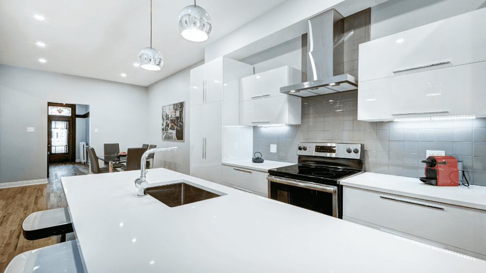 White kitchen with red mini grill and dining area with picture