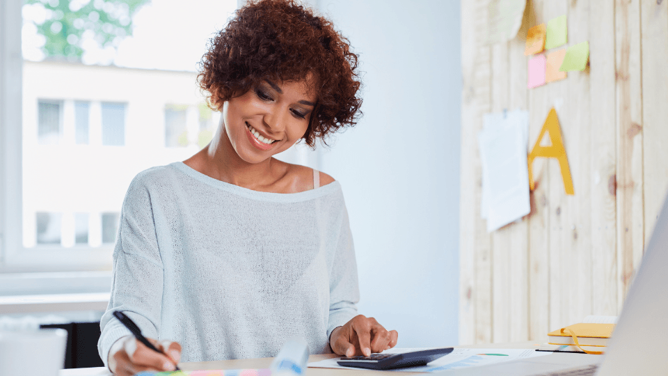 Woman with a pen and calculator sitting at the desk