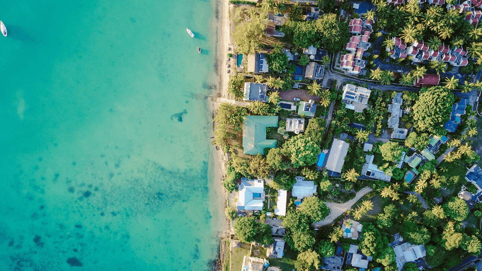 Eagle eye view of shoreline with a body of water and a neighborhood close by